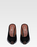 Sabots in black patent leather.