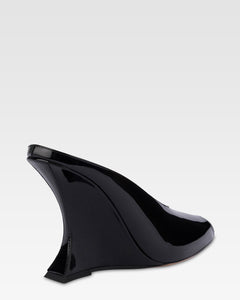 Sabots in black patent leather.