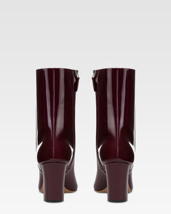 Ankle boots in rouge noir patent leather.
