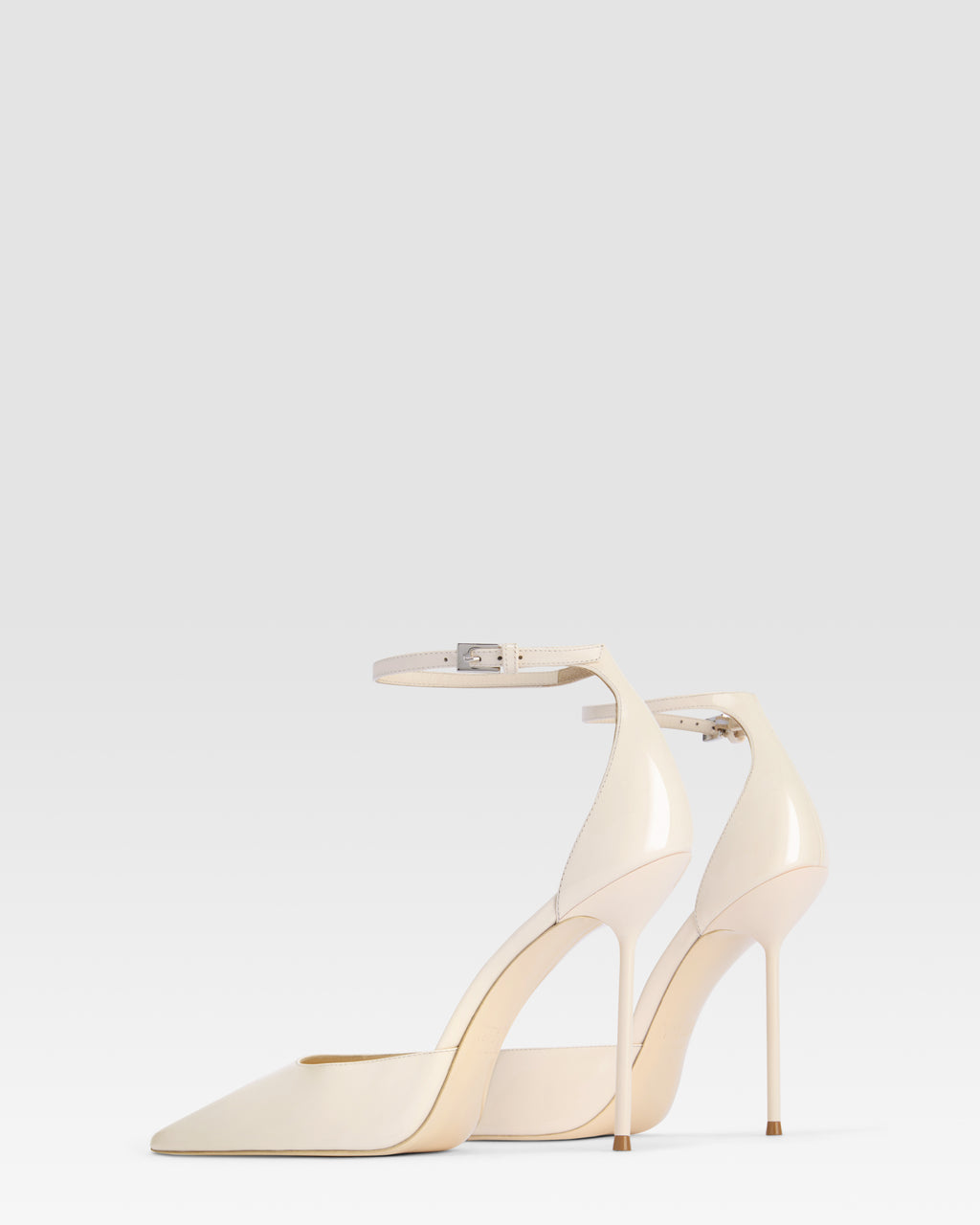 Pumps mit Knochelriemen aus elfenbeinfarbenem Lackleder