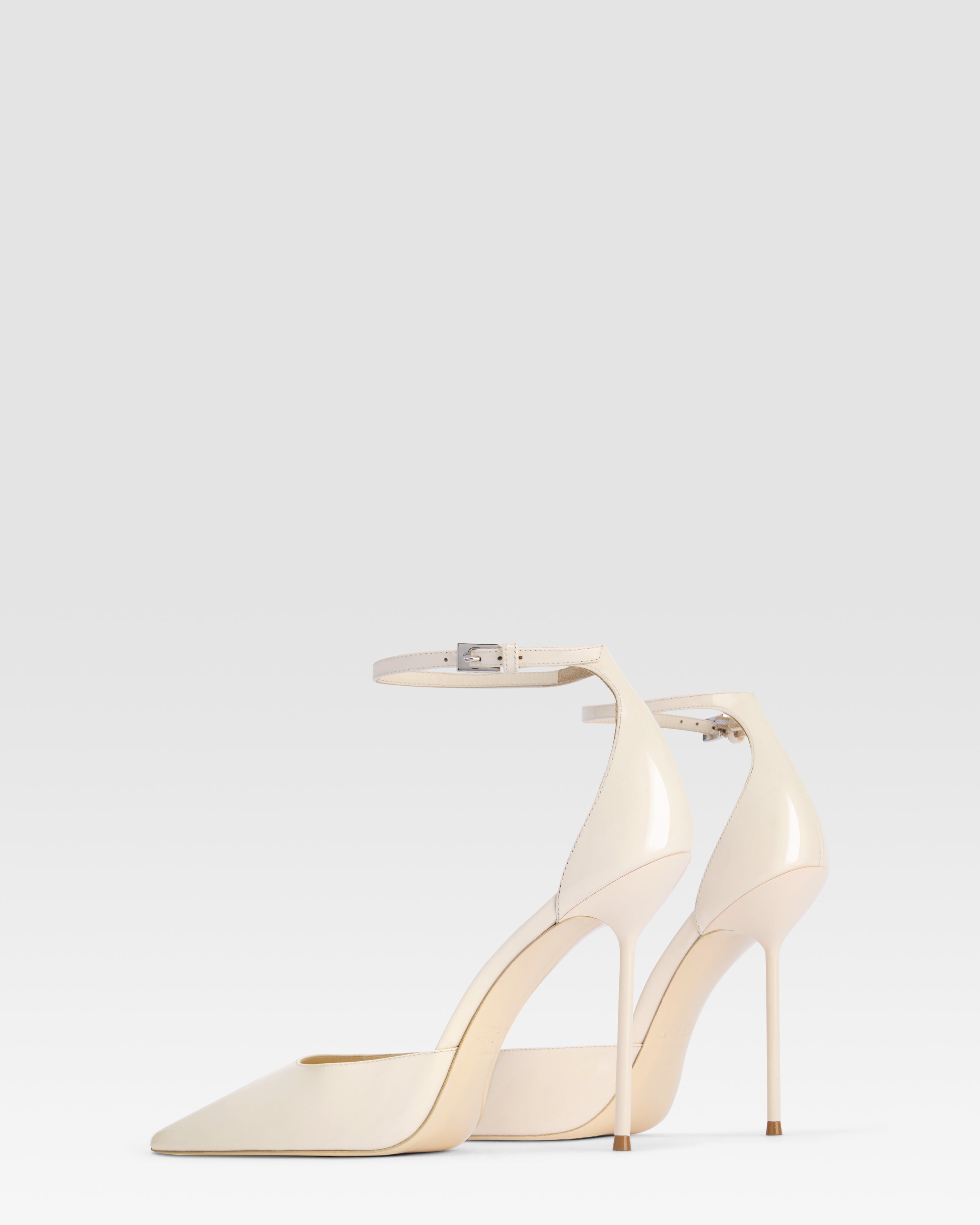 Pumps mit Knochelriemen aus elfenbeinfarbenem Lackleder