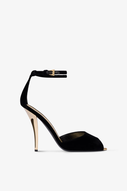 Sandalias de terciopelo de color negro con detalles dorados.