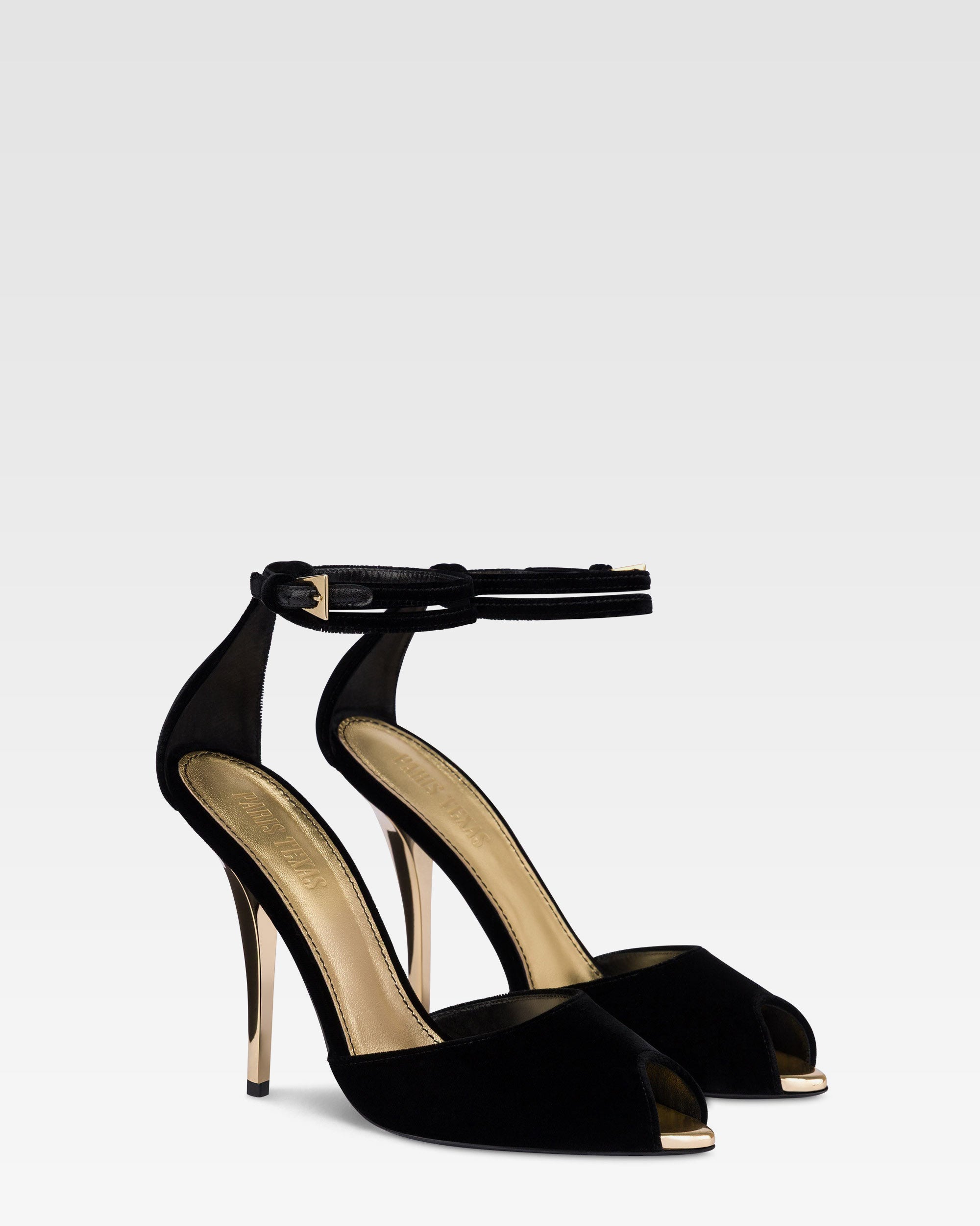 Sandalen aus schwarzem Samt mit goldenen Details.