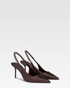 Zapatos destalonados de saten de color ebano con tachuelas.